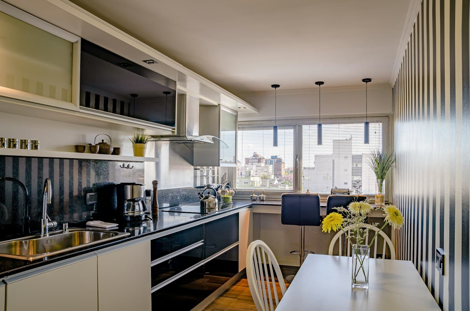 Cuisine équipée avec table et chaises près de la fenêtre