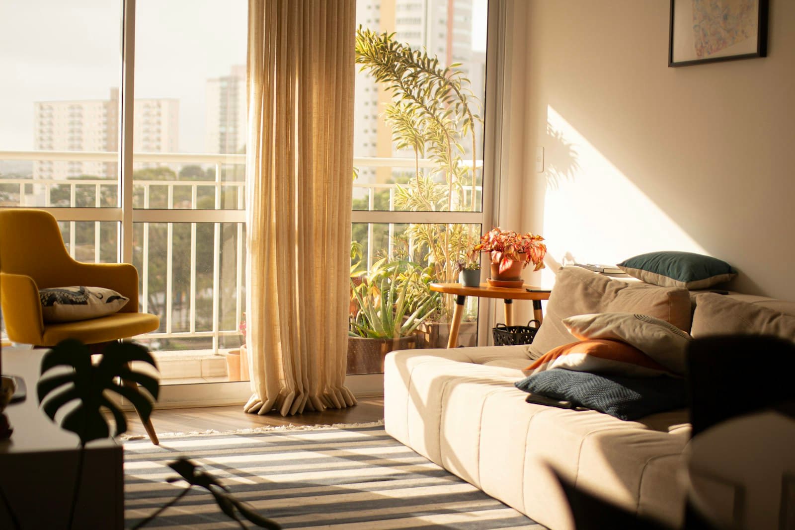 Séjour lumineux avec canapé, plantes et balcon